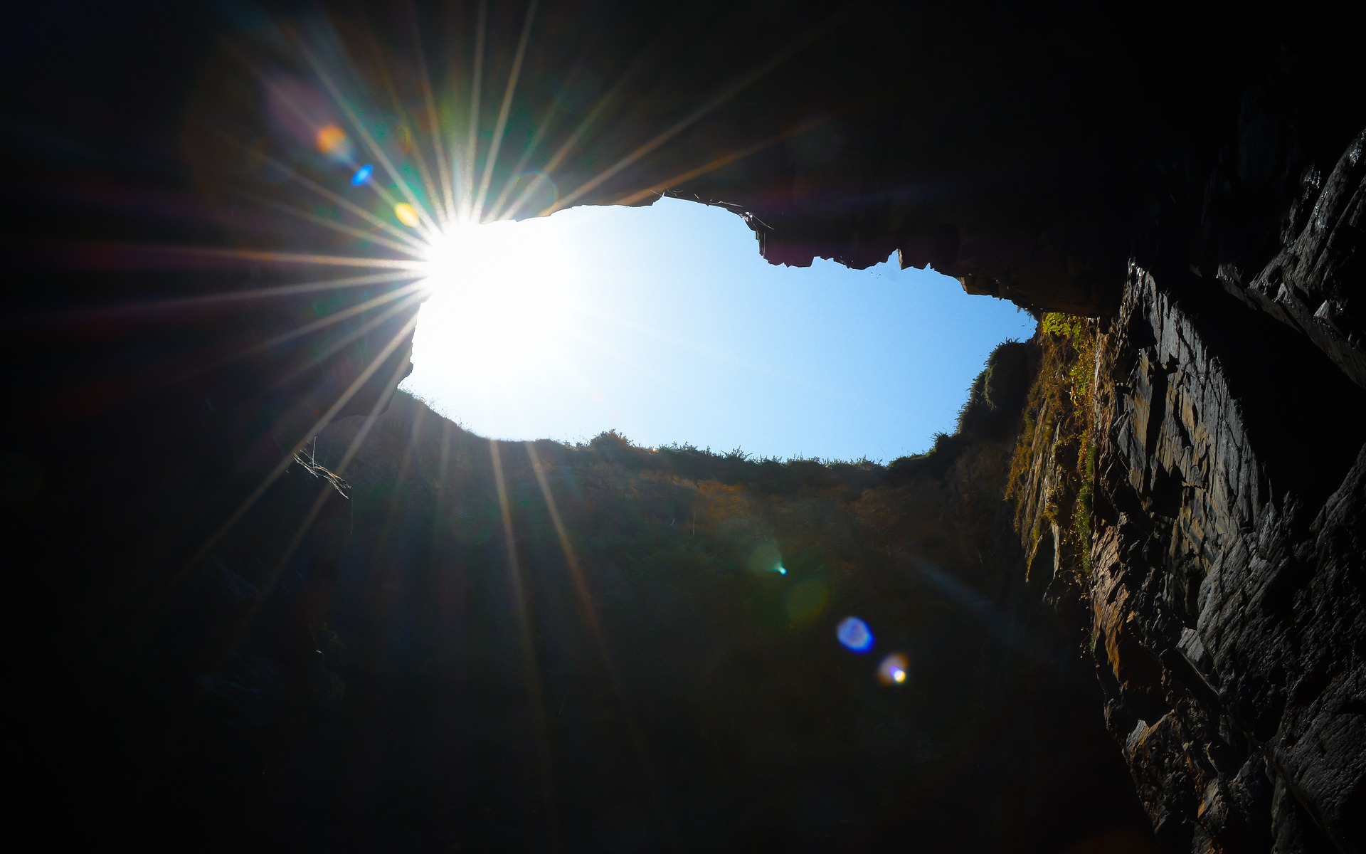 vista do sol e céu de dentro de uma caverna