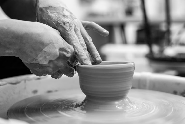 mãos moldando o barro em forma de vaso