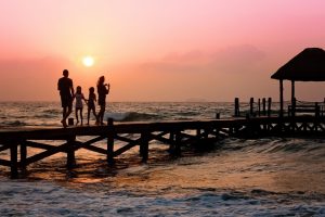 família andando em píer na praia